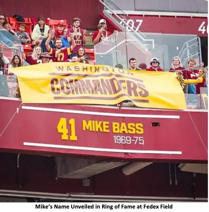 Mike's name unveiled on the stadium facade at FedExField: 41 MIKE BASS 1969-75 beneath a Washington Commanders banner, fans above